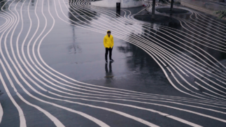 Romain Habousha Bijoute Production swing cercle homme debout avec veste jaune